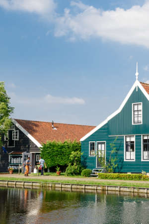 ZAANDAM, NETHERLANDS - JULY 4, 2016 : View of traditional small village houses in farm on cloudy sky. Zaanse Schans is popular with windmills.のeditorial素材