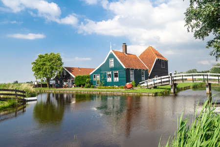 ZAANDAM, NETHERLANDS - JULY 4, 2016 : View of traditional small village houses in farm on cloudy sky. Zaanse Schans is popular with windmills.のeditorial素材