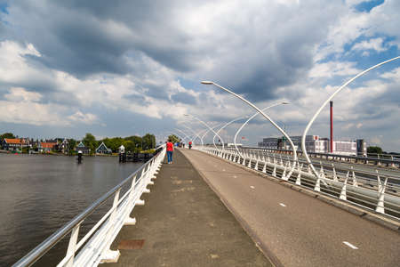 ZAANDAM, NETHERLANDS - JULY 4, 2016 : View of stone bridge on cloudy sky. Zaanse Schans is popular with windmills.のeditorial素材