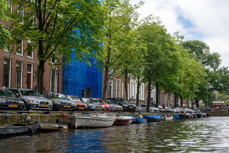 AMSTERDAM, NETHERLANDS - JULY 2, 2016 : View from tours with sailboats in canals on cloudy sky. Amsterdam is popular with canal tours.のeditorial素材