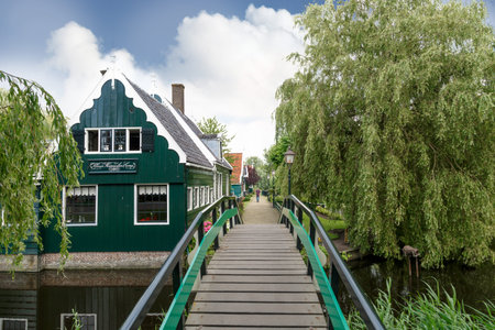 ZAANDAM, NETHERLANDS - JULY 4, 2016 : View of traditional small village houses in farm on cloudy sky. Zaanse Schans is popular with windmills.のeditorial素材