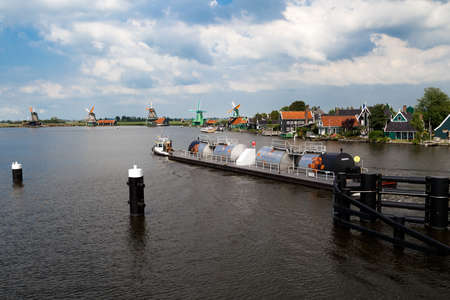 ZAANDAM, NETHERLANDS - JULY 4, 2016 : View of famous windmills in Zaanse Schans village on cloudy sky. Zaandam is popular with windmills.のeditorial素材