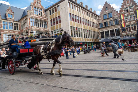 GENT, BELGIUM - JULY 6, 2016 : People in attraction and horse riding in Korenmarkt. This place is most popular square in Gent, Belgium.のeditorial素材