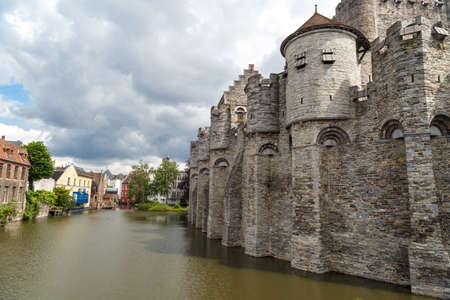 Medieval castle named Gravensteen (Castle of the Counts) on Leie River in Ghent, Belgium on cloudy sky.の写真素材