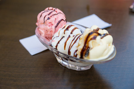 Close up detailed view of tasty chocolate and caramel ice cream with chocolate sauce served on glass...