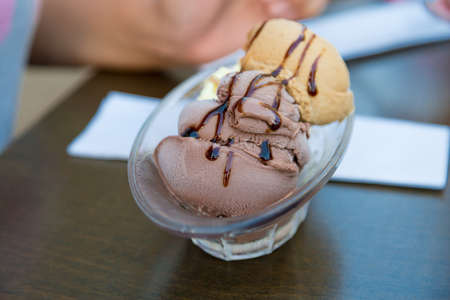 Close up detailed view of tasty chocolate and caramel ice cream with chocolate sauce served on glass cup.の写真素材