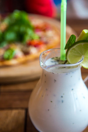 Close up detailed view of tasty cold ayran with fresh mint made with yoghurt and water.