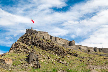 General bottom view of historical famous Kars Castle on meadow hill, Kars, Eastern Anatolia Region Turkey on cloudy sky background.のeditorial素材