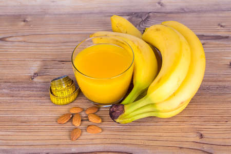Close up top view of fruits, bananas, orange juice, almond with healthy fit concept on wooden background.の写真素材
