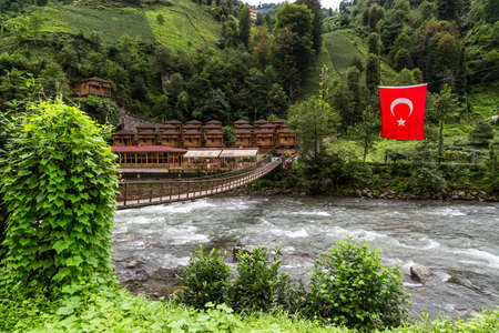 RIZE, TURKEY - AUGUST 17, 2016 : General landscape view of Turkish Flag and wooden draw bridge on Firtina River in Camlihemsin, Rize, Turkey among green trees.のeditorial素材