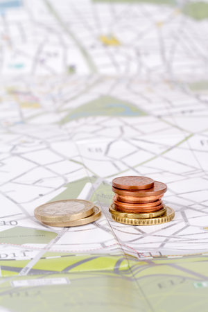 Euro coins with city map background in touristic travel and finance concept.