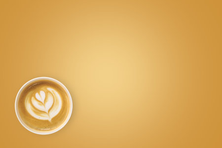 Top view of flower sign designed cup of coffee with copy space mock up area on golden background.