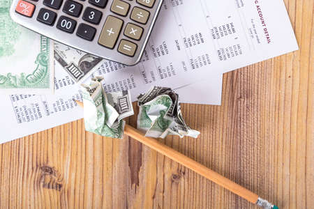 Finance and business concept, hundred dollar banknotes with pencil and calculator on earning report.の写真素材