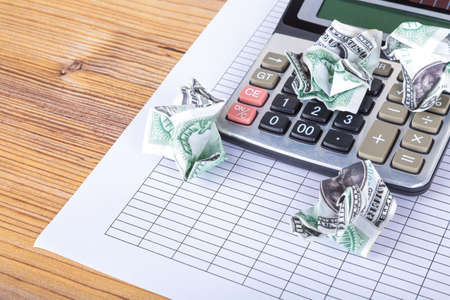 Finance and business concept, dollar banknotes money and calculator on blank report paper.の写真素材