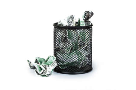 Dollar banknotes crumpled inside garbage basket, rubbish bin focused on consuming money in finance concept, isolated on white background.の写真素材