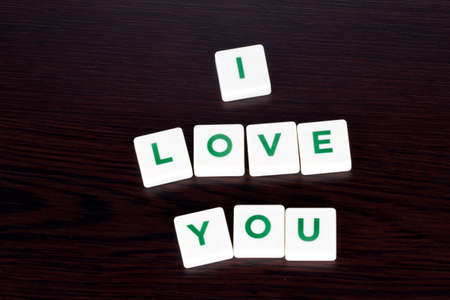 Word love you with green and white letters on wooden background.の写真素材