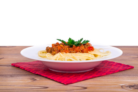 Side view of plate of spaghetti pasta with tomato bolognese sauce, isolated on white background.の写真素材