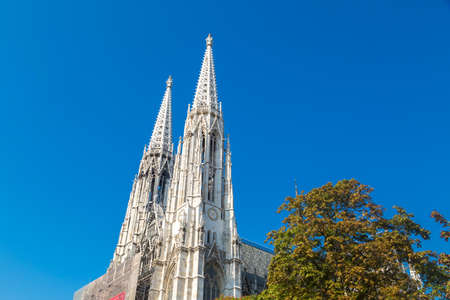 Exterior view of fFamous Votivkirche, Votive Church in Vienna, neo-gothic church located in Ringstrasse on blue sky background.のeditorial素材