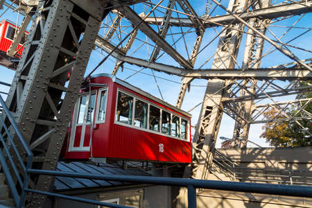 View of famous historic red and the oldest ferris wheel of Europe, cabin up in the air on Prater Park.の写真素材