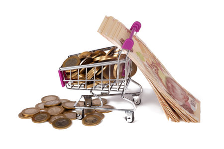 Stack of Turkish Lira banknotes and coins in shopping cart with money consuming and finance concept, isolated on white background.の写真素材