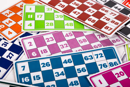 Colorful lotto or bingo game papers with numbers and plastic lotto barrels, isolated on white background.の写真素材