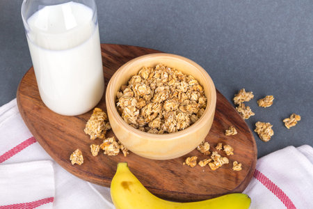 View of fit and healthy breakfast with muesli cereal in bowl and milk in bottle and banana on...
