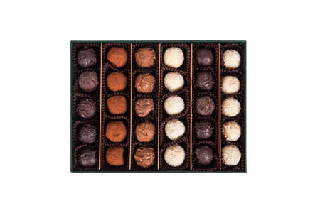 Top view of yummy tasty white, dark and milky chocolate balls in green box, isolated on white background.の写真素材