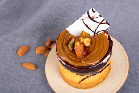 Yummy tasty cake with cream, nuts and caramel sauce, served with almonds.の写真素材