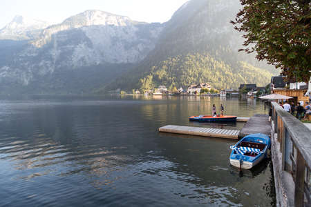HALLSTATT, AUSTRIA - SEPTEMBER 14, 2016 : Landscape view of Hallstatt Lake also known as Hallstatt See, with a pier and boats in clear water among high Alp Mountains.のeditorial素材