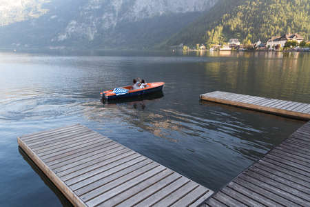 HALLSTATT, AUSTRIA - SEPTEMBER 14, 2016 : Landscape view of Hallstatt Lake also known as Hallstatt See, with a pier and boats in clear water among high Alp Mountains.のeditorial素材