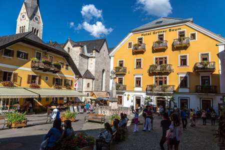 HALLSTATT, AUSTRIA - SEPTEMBER 14, 2016 : Scenic view of Hallstatt market square with historic mountain houses and cafes around, among high Alp mountains with big trees.のeditorial素材