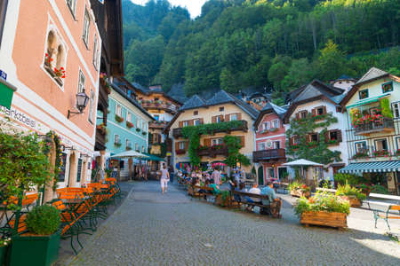 HALLSTATT, AUSTRIA - SEPTEMBER 14, 2016 : Scenic view of Hallstatt market square with historic mountain houses and cafes around, among high Alp mountains with big trees.のeditorial素材