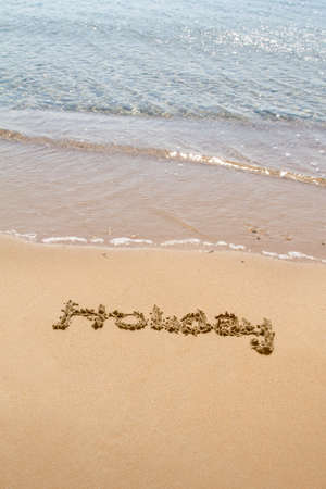 Word of holiday written with letters on sand.の写真素材