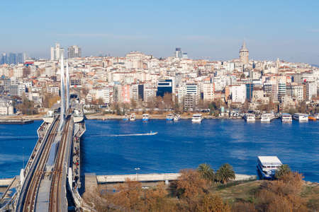 ISTANBUL, TURKEY - DECEMBER 09, 2016 : Panoramic cityscape view of historical center of Istanbul city, with metro bridge above golden horn on bright blue sky background.のeditorial素材