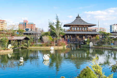 KONYA, TURKEY - NOVEMBER 11, 2017 : Landscape view of Kyoto Japan Garden in Konya with small lake and wooden buildings around, among big apartments on cloudy sky background.のeditorial素材