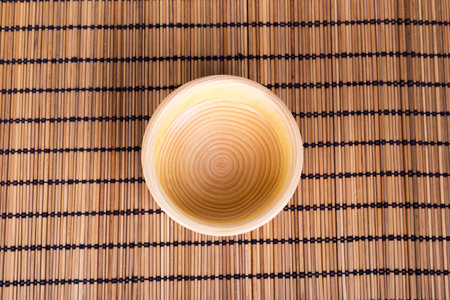 Top view of empty wood plate with wooden place mat.
