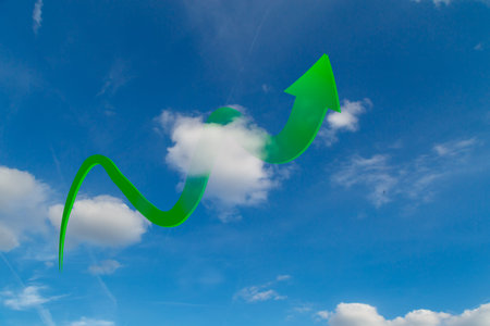 Green arrow rises in clouds on blue sky.
