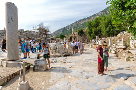EPHESUS, TURKEY - JUNE 20, 2018 : Ruins in historical ancient city Ephesus with restoration and tourists around on cloudy sky in Izmir, Turkey.のeditorial素材