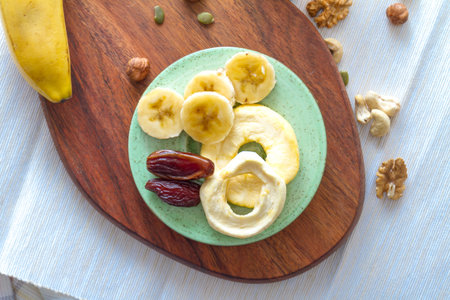 Mix of dried fruits, nuts and healthy served on wooden plate on tableの写真素材