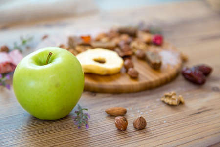 Top view of mixed food and nuts with fruits, served on wooden plate.の写真素材