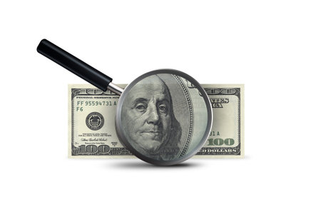 Finance concept, magnifying glass with one hundred dollar banknote showing, isolated on white...
