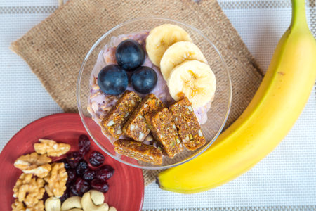 Close up view of cup and raw vegan energy sweets, bars with mix of fruits and nuts. Lifestyle...