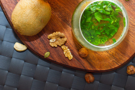 Healthy snack eating and drinking concept with green tea and mix of nuts, raw bars, fruits, served on wooden plate.の写真素材