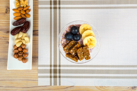 Close up view of cup and raw vegan energy sweets, bars with mix of fruits and nuts. Lifestyle...