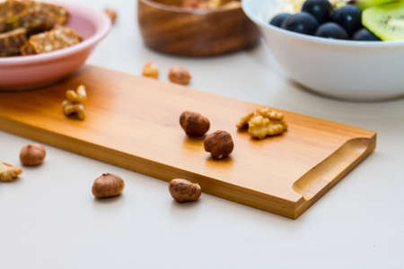 Healthy eating concept. Close up view of nuts, date palm in wooden plate on table.の写真素材