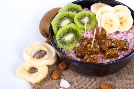 Healthy lifestyle, mix of energy fruits like kiwi, banana and dried nuts and raw energy bars in cup, breakfast snack concept, isolated on white background.の写真素材