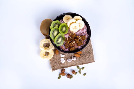 Healthy lifestyle, mix of energy fruits like kiwi, banana and dried nuts and raw energy bars in cup,...