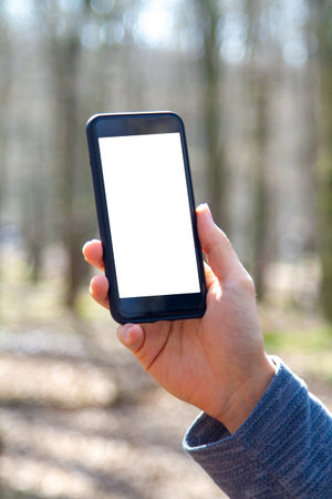Mockup image of smart phone with white blank screen template, hand holding and showing mobile in...