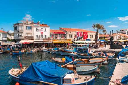 IZMIR,  TURKEY - JUNE 05, 2019 : Fishing boats in touristic place of Aegean Region in Phocaea Town with old and historical, traditional architecture buildings. Phocaea is ancient city in old dates.のeditorial素材