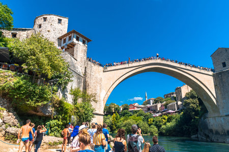 MOSTAR, BOSNIA - AUGUST 4, 2019 : View of Old Mostar Bridge on Neretva River with people. Mostar is one of the most famous place of Balkans.のeditorial素材